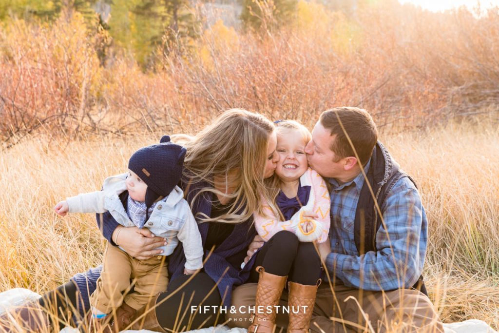 A mom and dad kiss their five-year-old and smush her cheeks for their Hope Valley family portraits