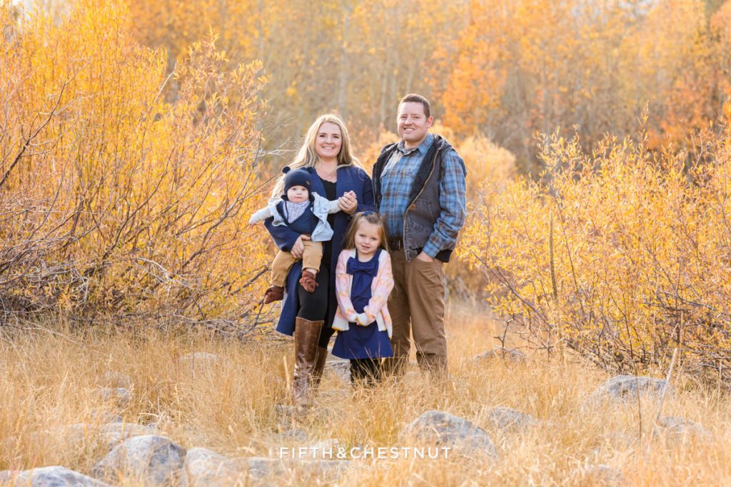 A family of four stands together and smile for their Hope Valley family portraits by Hope Valley Photographer in October