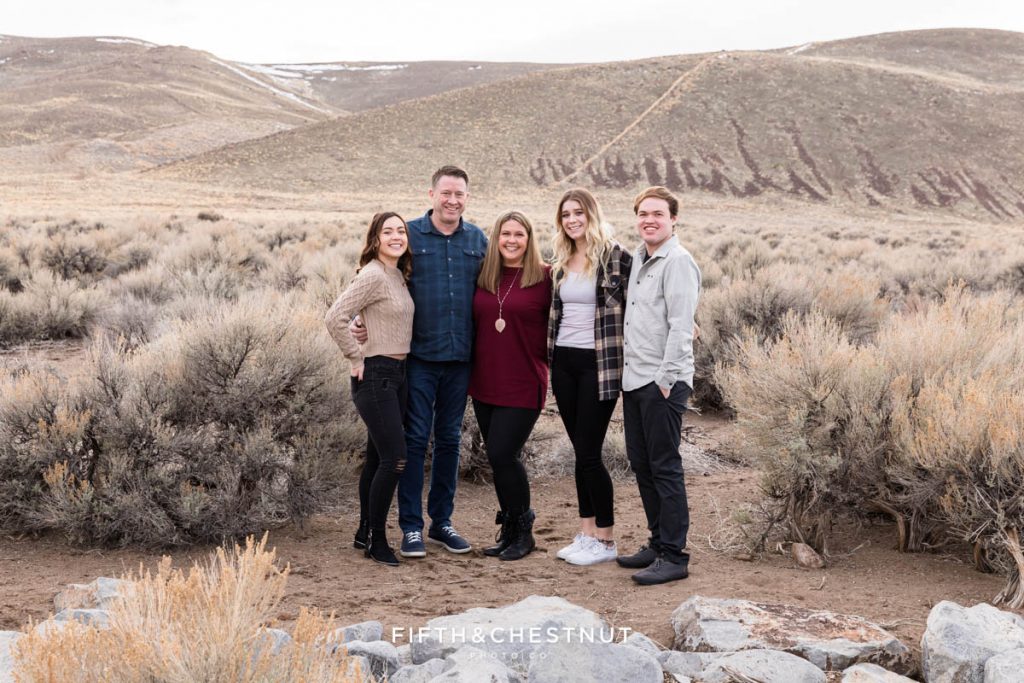 Desert Family Portraits of a family of five wearing dark tones with against a neutral desert backdrop by Reno Family Photographer