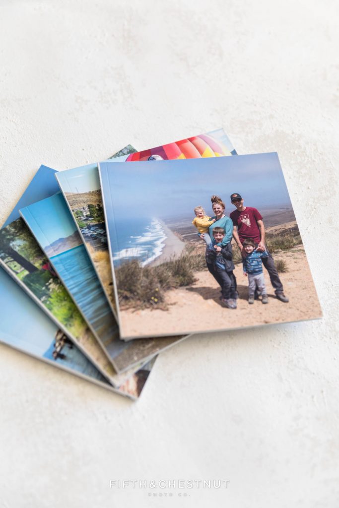 A stack of monthly chatbook albums to show how to preserve your memories by a Reno Family Photographer who is passionate about clients printing their digital images.