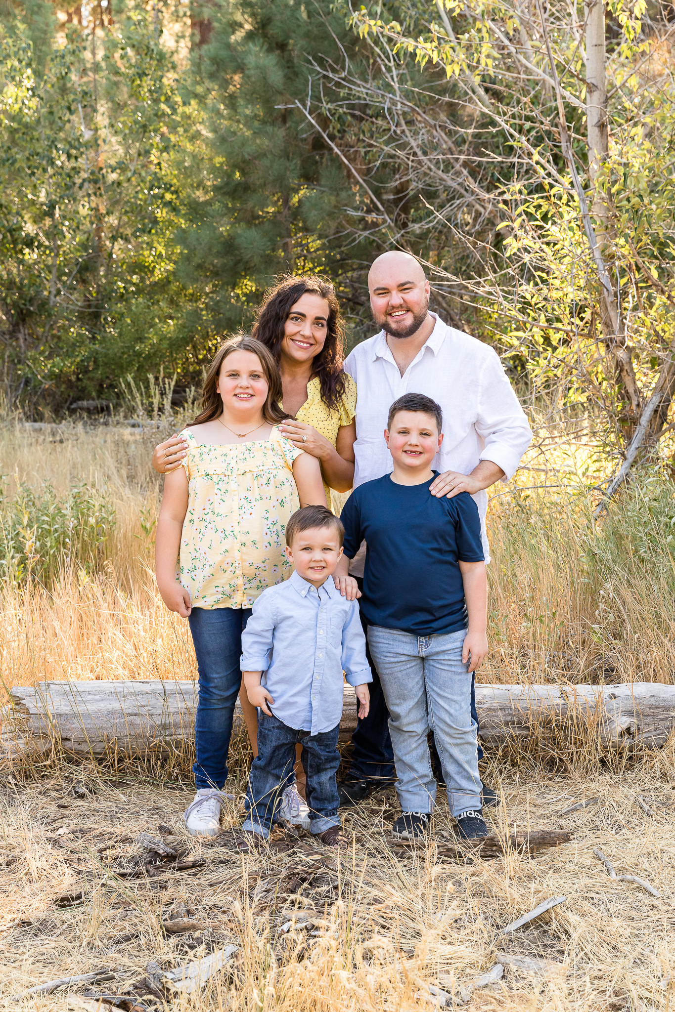 A gorgeous summer family portrait in Reno of a family wearing yellow, white and denim blue in a meadow by Reno Family Photographer