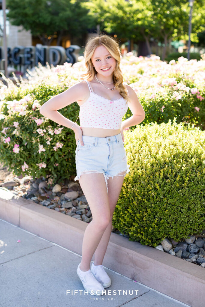 Gorgeous summer Reno senior portraits of a girl wearing a floral white top and bleached jean shorts in July by Reno Senior Photographer