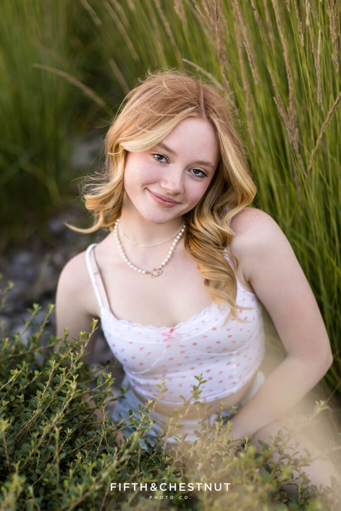 Gorgeous summer Reno senior portraits of a girl wearing a floral white top and bleached jean shorts in July by Reno Senior Photographer