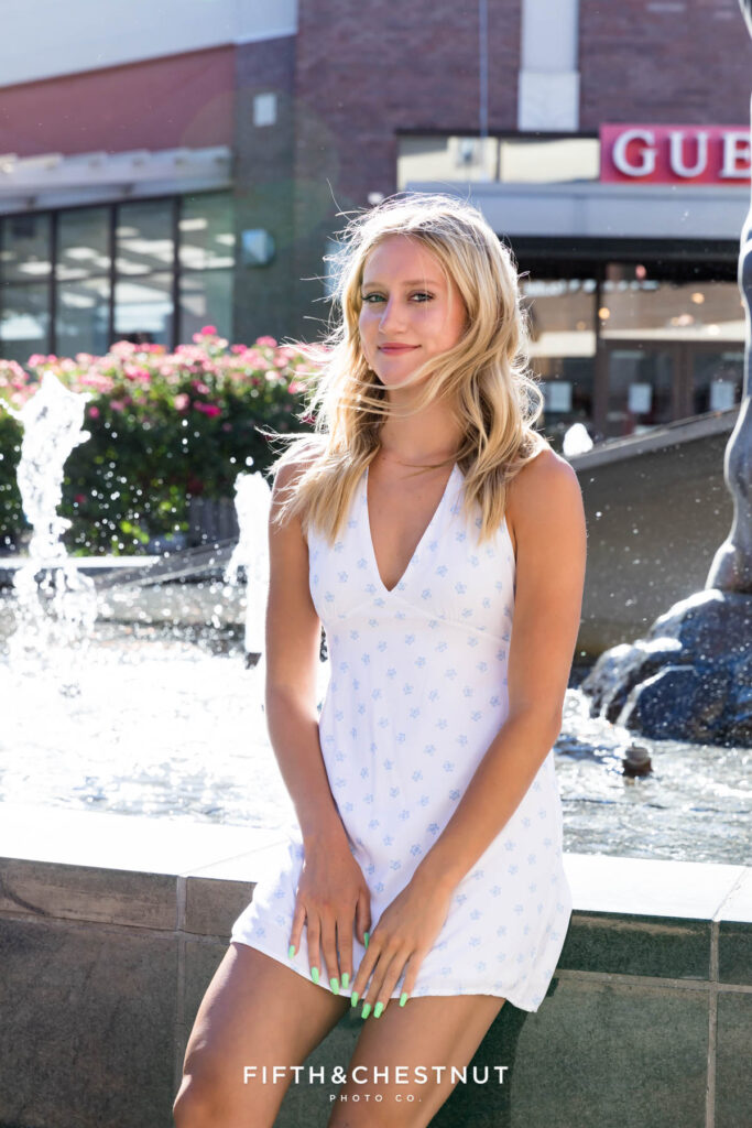 Stunning and sunny summer Reno Senior Photos of Rylan in front of a water fountain during a creative teen photoshoot in July.