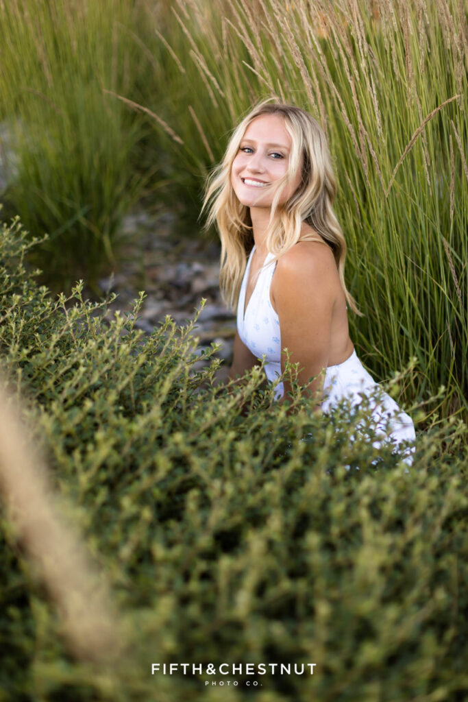 Stunning and sunny summer Reno Senior Photos of Rylan in tall grass with a white mini dress.