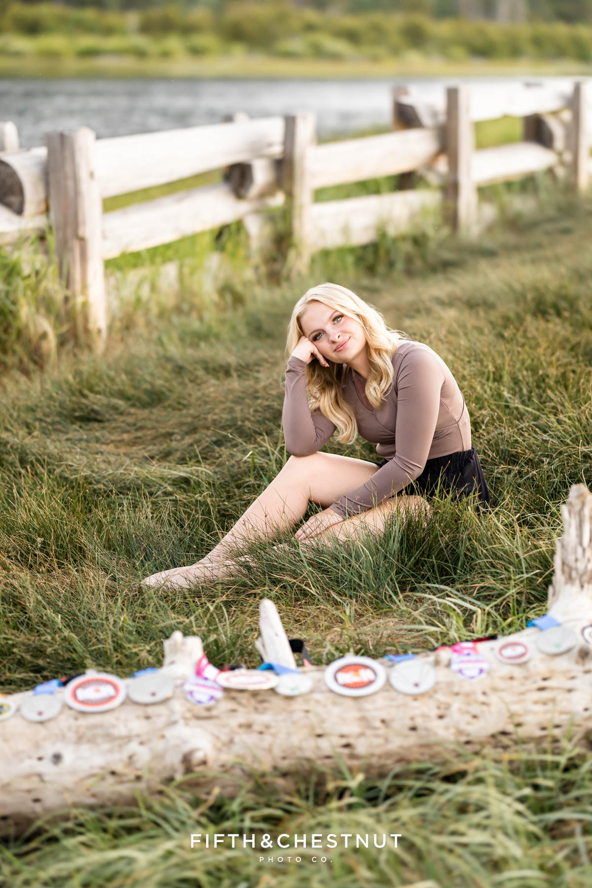 Reno High School Senior sitting in the grass near her dance medals at the beach