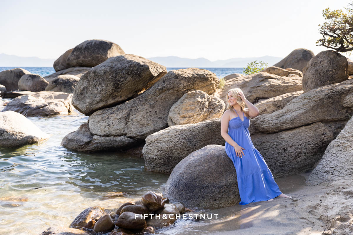 Bishop Manogue Senior in a flowing blue dress standing by large granite boulders in Tahoe