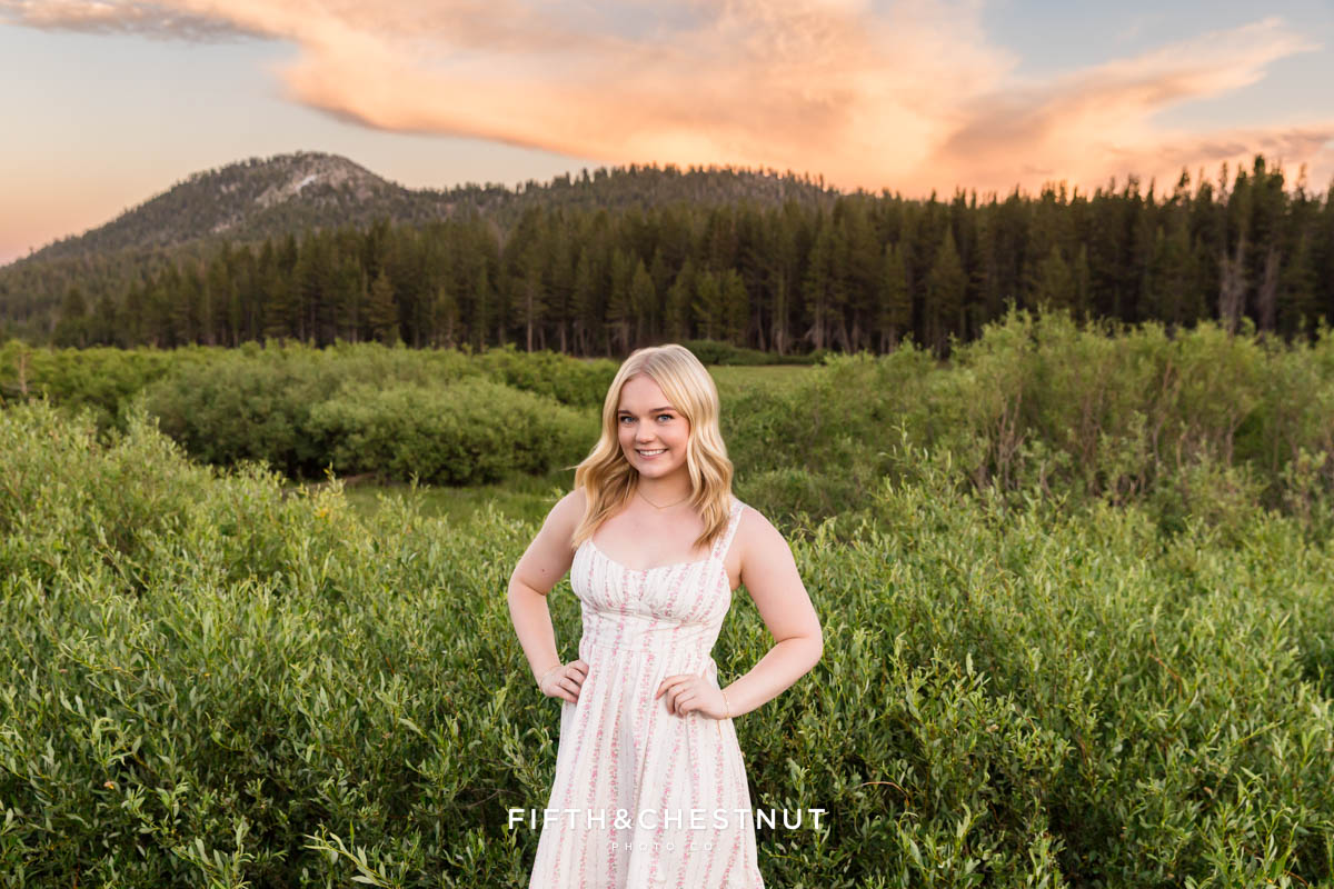 A vibrant orange and pink sunset behind a Reno senior at the end of her senior session with Tahoe Senior Photographer