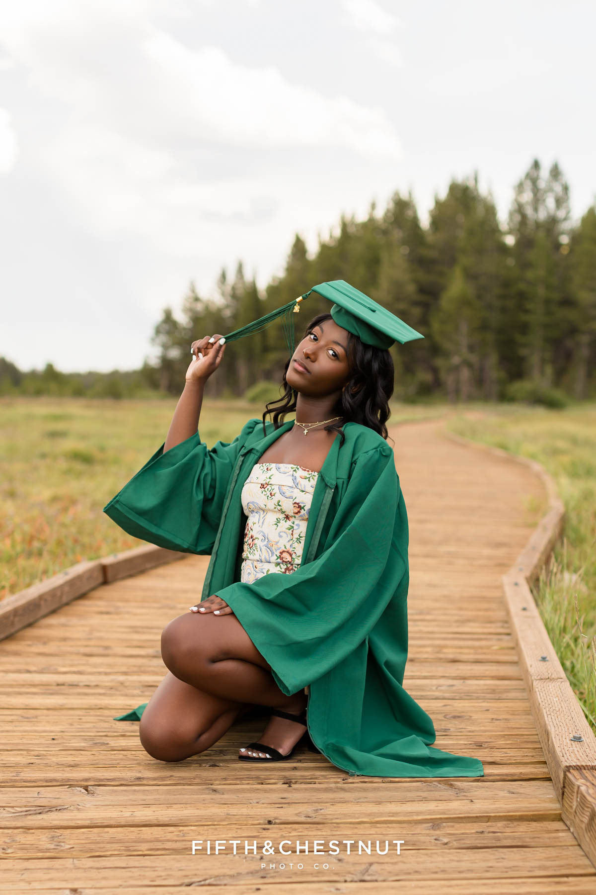 Senior wearing cap and gown in Tahoe meadow above Incline Village – flower farm senior photos in Reno/Tahoe