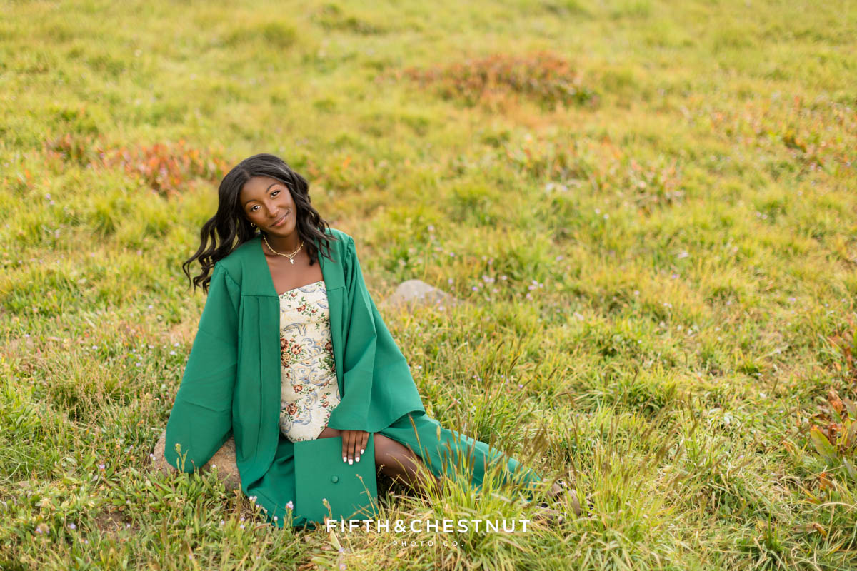 Senior wearing cap and gown in Tahoe meadow above Incline Village – flower farm senior photos in Reno/Tahoe
